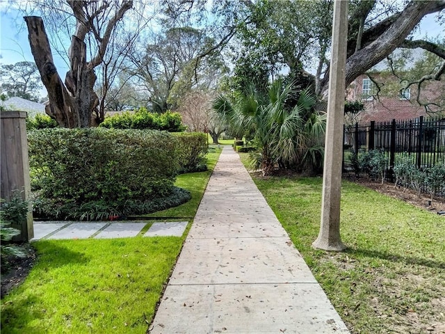 view of property's community featuring fence and a lawn