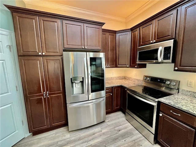 kitchen featuring dark brown cabinetry, light wood-style flooring, ornamental molding, light stone countertops, and stainless steel appliances