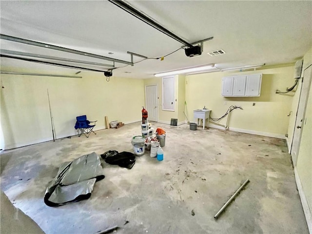 garage with a sink, visible vents, and a garage door opener