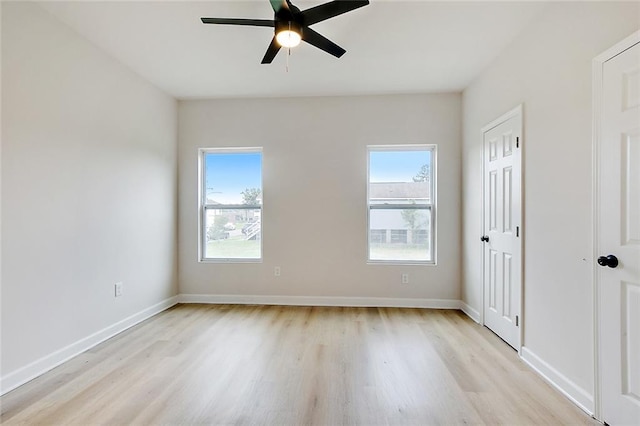 unfurnished room with a healthy amount of sunlight, light wood-style flooring, and baseboards