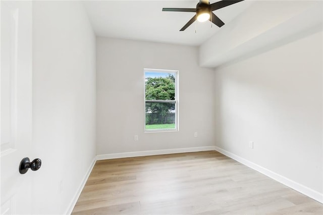 empty room with light wood-type flooring, a ceiling fan, and baseboards