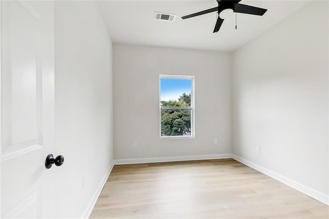 empty room featuring light wood-style flooring, visible vents, baseboards, and a ceiling fan