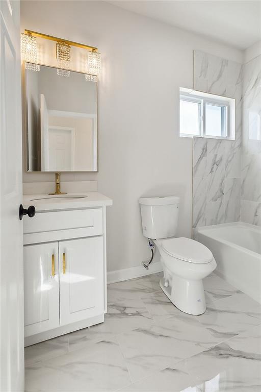 full bath with marble finish floor, baseboards, vanity, and toilet