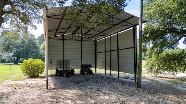 view of outdoor structure with driveway and a carport