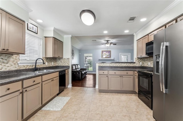 kitchen featuring visible vents, dark countertops, a peninsula, black appliances, and a sink