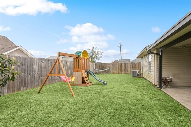 view of playground featuring a fenced backyard, a yard, and central AC