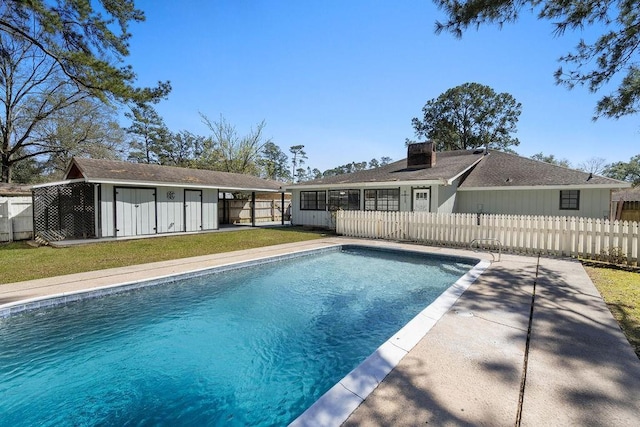 view of pool with a fenced in pool, fence private yard, an outdoor structure, and a lawn