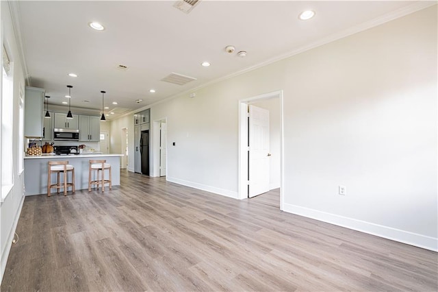 unfurnished living room featuring ornamental molding, recessed lighting, baseboards, and light wood finished floors