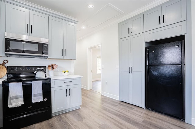 kitchen with crown molding, recessed lighting, light countertops, light wood-style floors, and black appliances