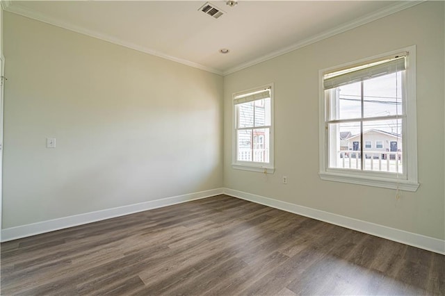 spare room featuring ornamental molding, visible vents, dark wood finished floors, and baseboards