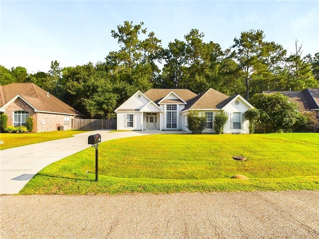 ranch-style home featuring concrete driveway, a front yard, and fence