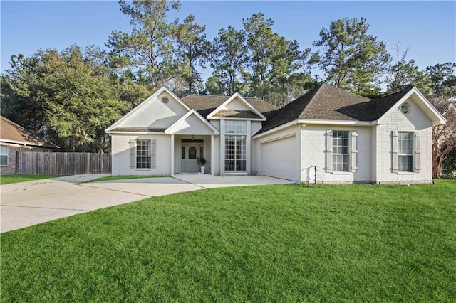 view of front of house featuring a garage, driveway, fence, a front yard, and brick siding