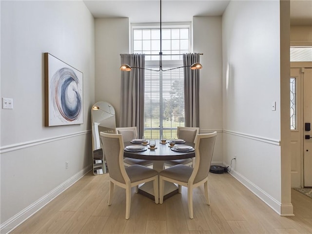 dining space featuring light wood-style flooring and baseboards