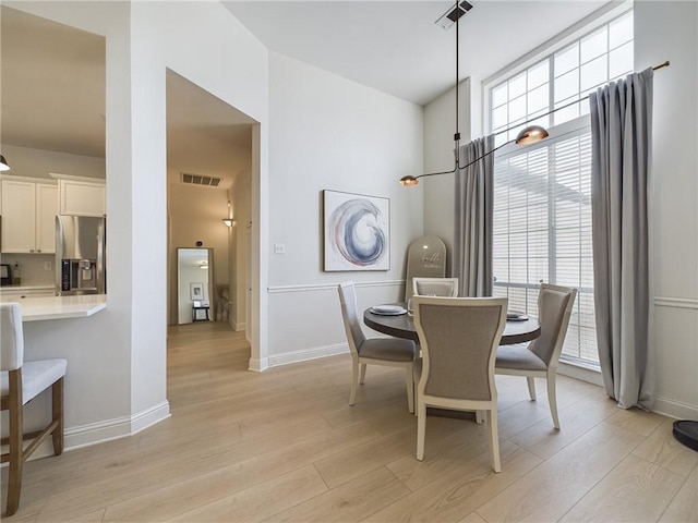 dining room with visible vents, light wood-style flooring, baseboards, and an inviting chandelier