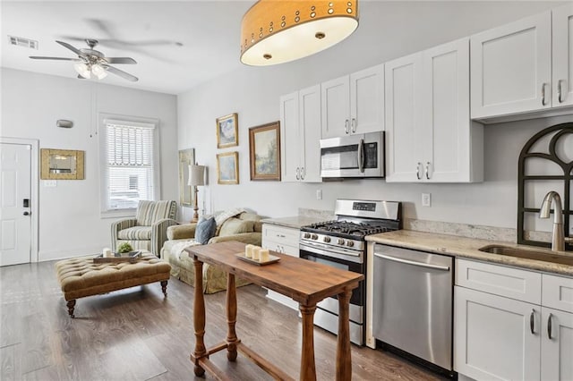 kitchen featuring visible vents, a sink, dark wood finished floors, stainless steel appliances, and ceiling fan