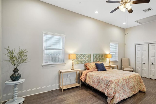 bedroom with wood finished floors, visible vents, baseboards, attic access, and a closet