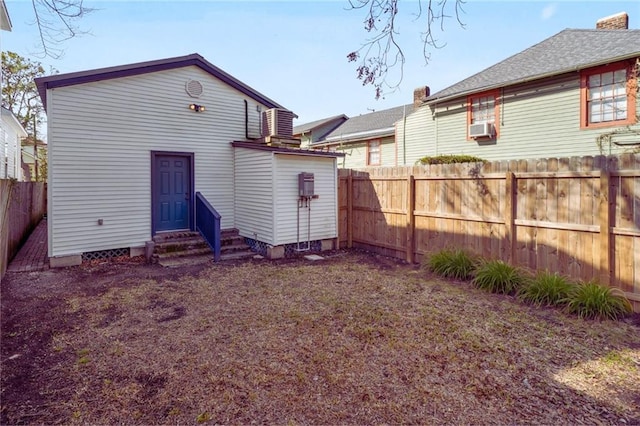 rear view of house with cooling unit, central AC, a fenced backyard, and entry steps