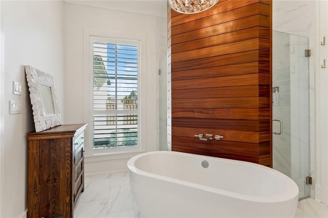 full bath featuring a freestanding bath, marble finish floor, a marble finish shower, and vanity