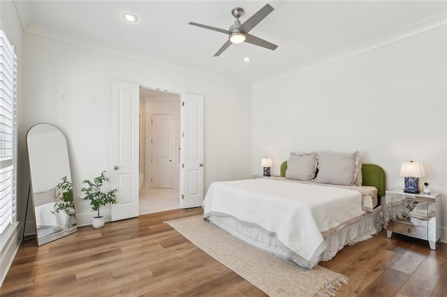 bedroom with a ceiling fan, recessed lighting, crown molding, and light wood-style flooring