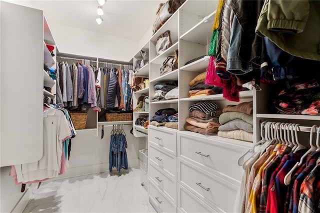 walk in closet featuring marble finish floor