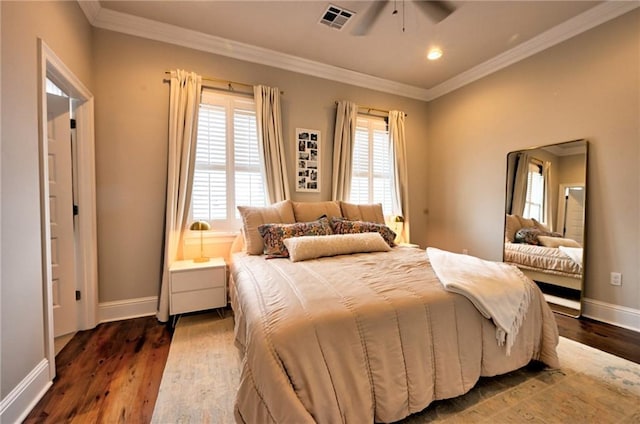 bedroom with baseboards, dark wood-style flooring, visible vents, and crown molding