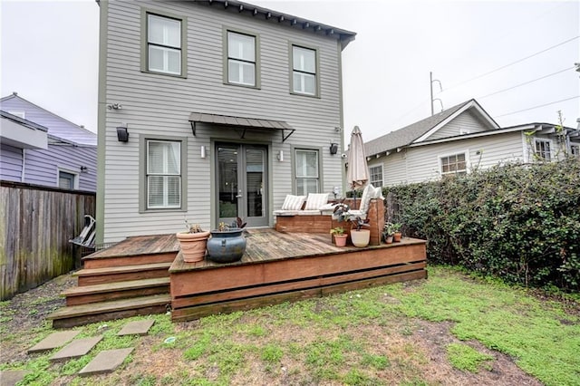 back of property featuring french doors, a fenced backyard, and a wooden deck