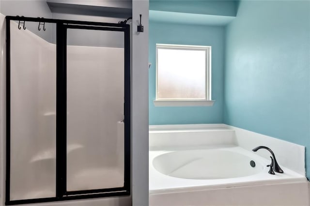 bathroom featuring a stall shower and a garden tub