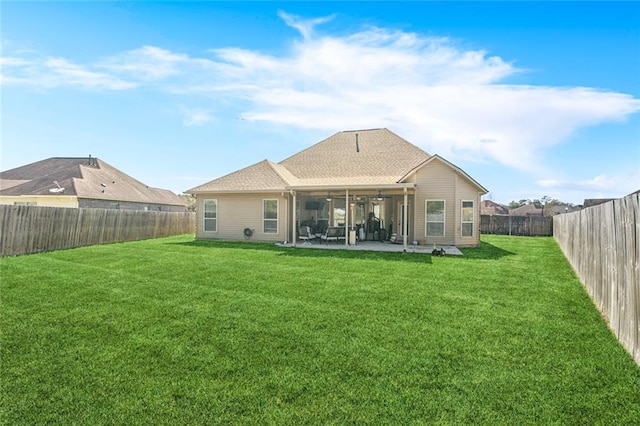 rear view of property featuring a patio, a lawn, a fenced backyard, and roof with shingles