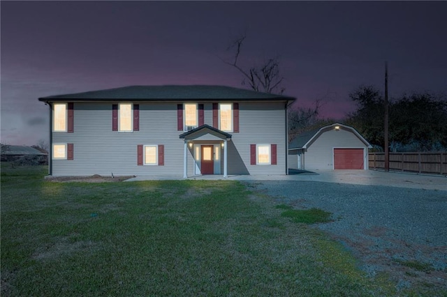 view of front of property featuring a front yard, fence, a garage, driveway, and an outdoor structure