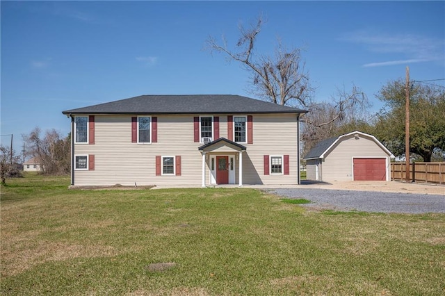 view of front of home with a garage, a front lawn, an outdoor structure, and fence