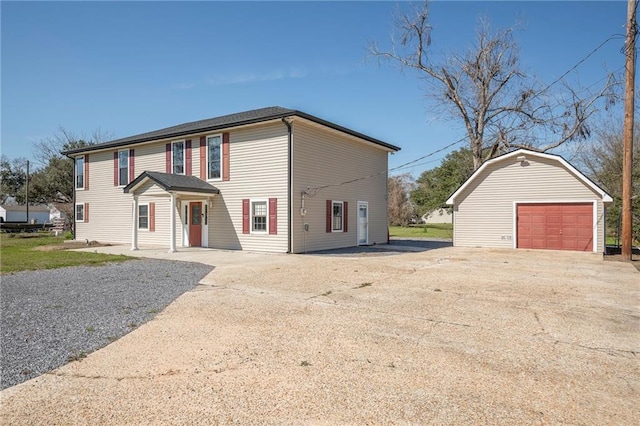 view of front facade featuring driveway, an outdoor structure, and a detached garage