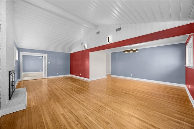 unfurnished living room with a fireplace, a notable chandelier, visible vents, light wood-style flooring, and baseboards