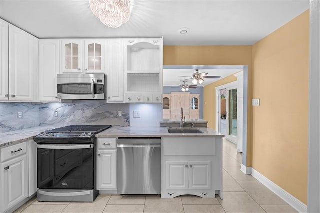 kitchen with stainless steel appliances, a sink, and white cabinets