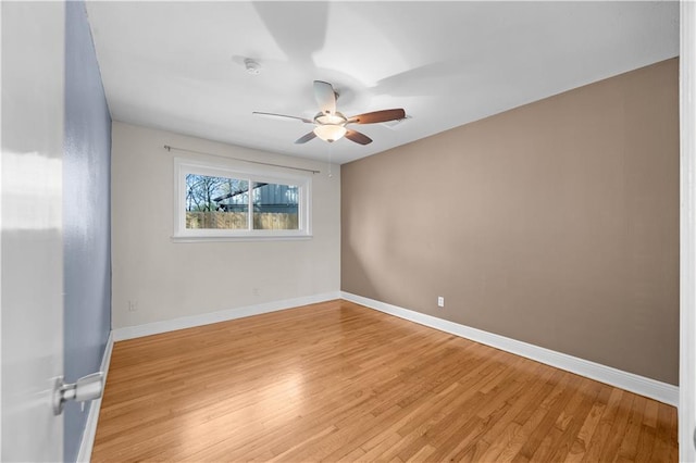 unfurnished room featuring a ceiling fan, light wood-style flooring, and baseboards