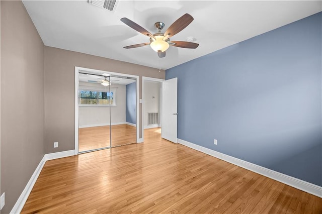 unfurnished bedroom featuring a closet, visible vents, light wood-style floors, a ceiling fan, and baseboards