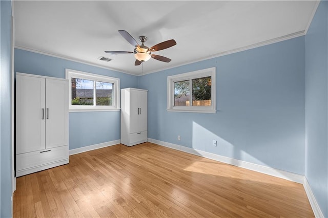 unfurnished bedroom with light wood-type flooring, baseboards, visible vents, and ornamental molding