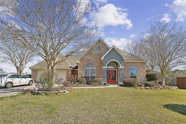 view of front of house featuring an attached garage, brick siding, fence, driveway, and a front lawn