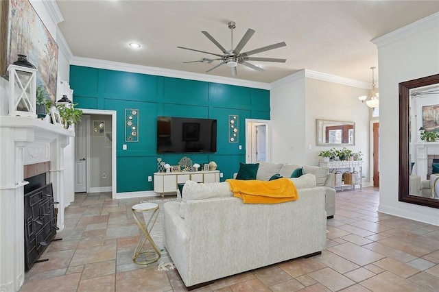 living room with ornamental molding, a fireplace, baseboards, and ceiling fan with notable chandelier