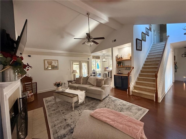 living room featuring a fireplace, visible vents, wood finished floors, beamed ceiling, and stairs