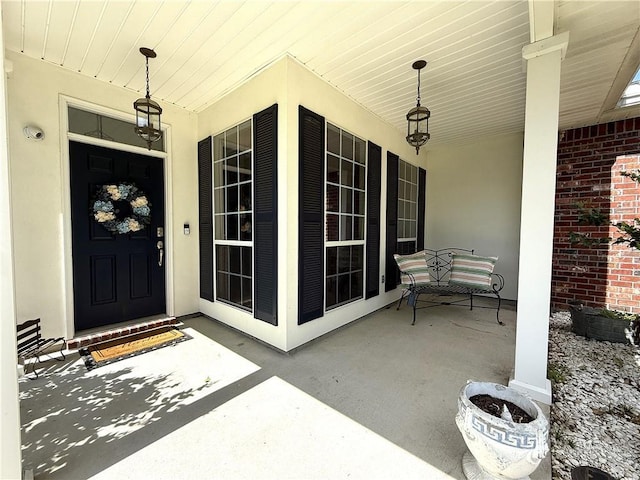doorway to property featuring stucco siding and a porch