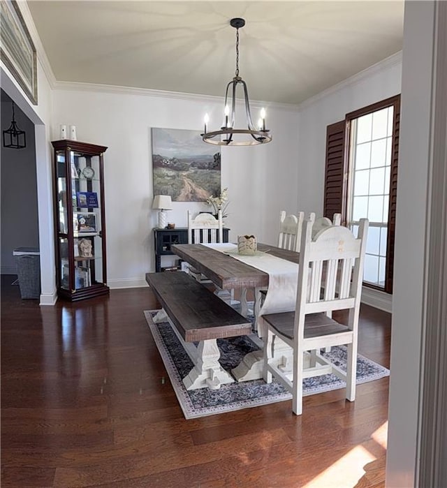 dining room with baseboards, crown molding, an inviting chandelier, and wood finished floors