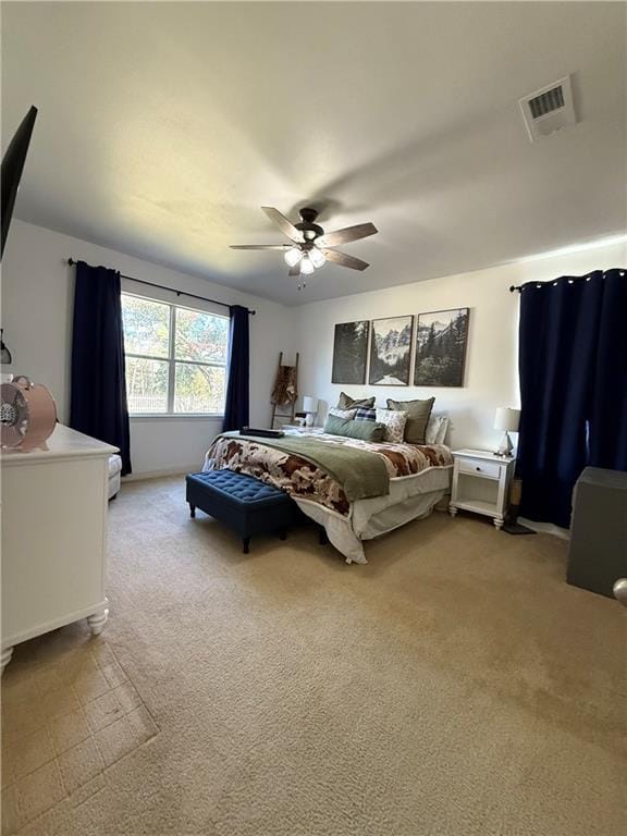 bedroom with visible vents, a ceiling fan, and light colored carpet