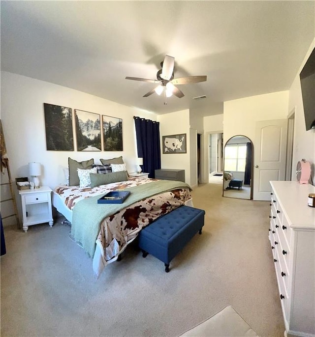 bedroom featuring light carpet and a ceiling fan