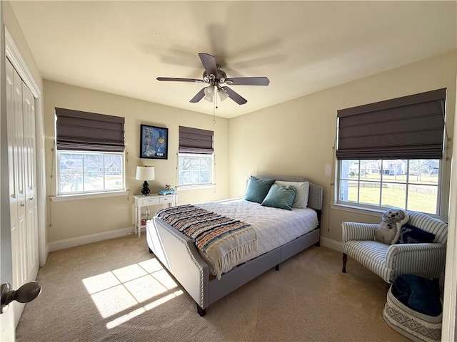 bedroom featuring multiple windows, light carpet, and baseboards