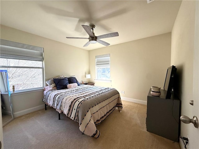 bedroom featuring baseboards, ceiling fan, and light colored carpet