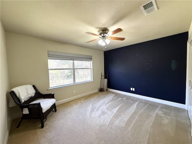 unfurnished room featuring light carpet, baseboards, visible vents, and a ceiling fan