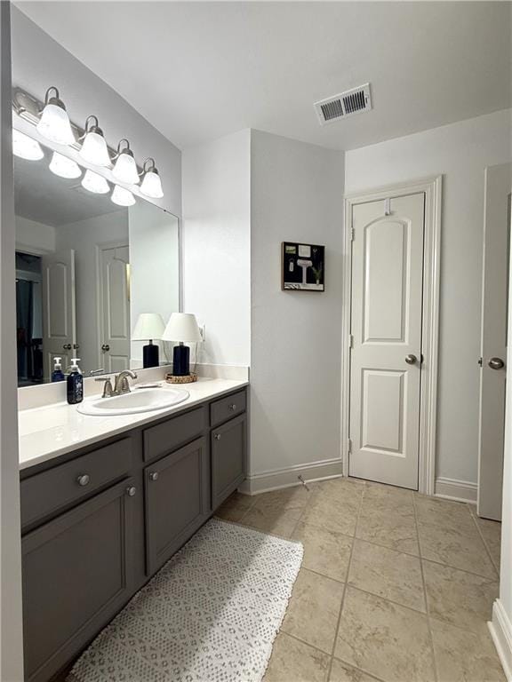 bathroom with baseboards, visible vents, tile patterned flooring, and vanity