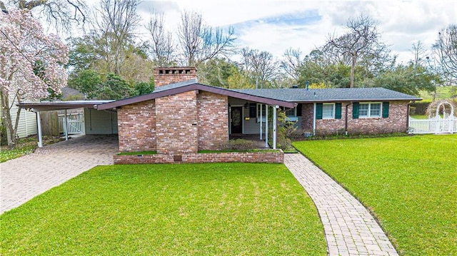 view of front of house featuring a front yard, brick siding, driveway, and an attached carport