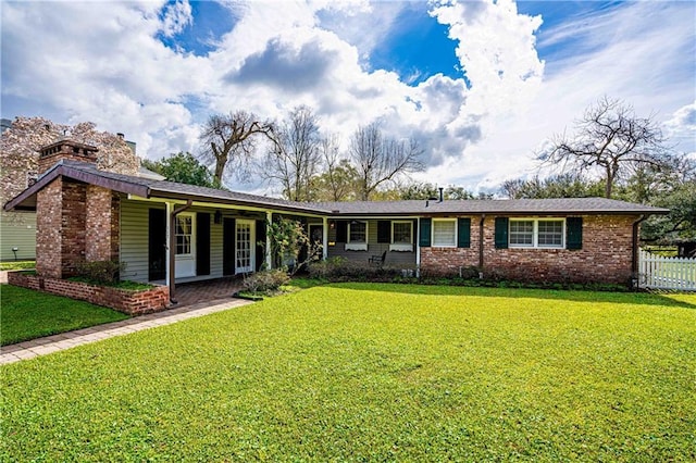 ranch-style house with a chimney, a front yard, and fence