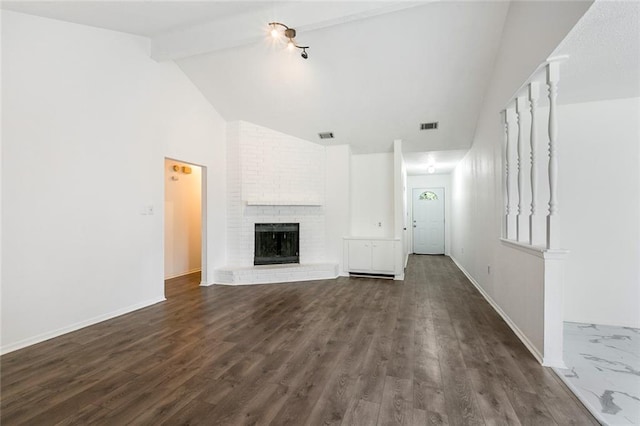 unfurnished living room with visible vents, a brick fireplace, beam ceiling, and baseboards